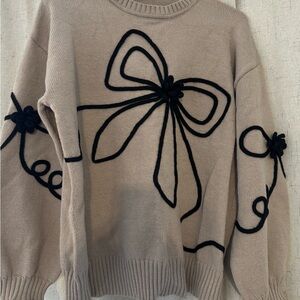 Elegant Beige Sweater with Black Bow Design